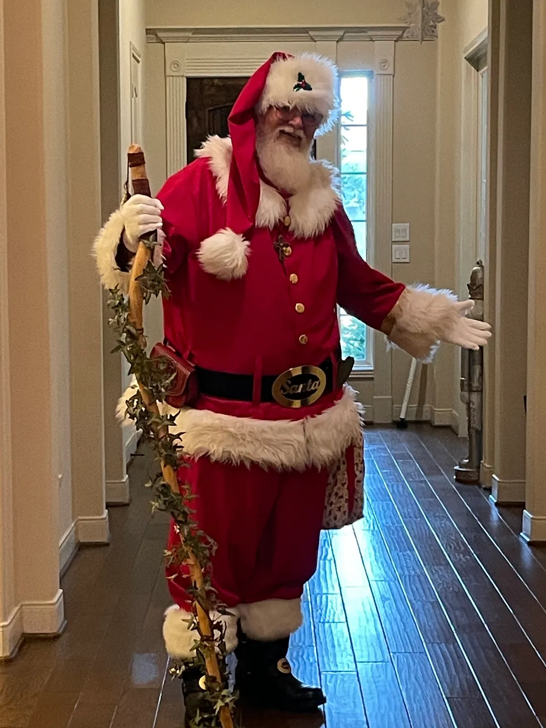 A man dressed as santa claus holding a staff.