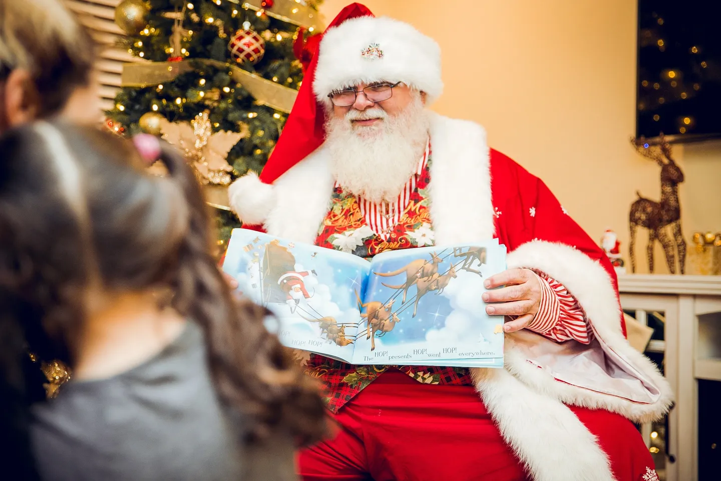 A man dressed as santa claus reading a book