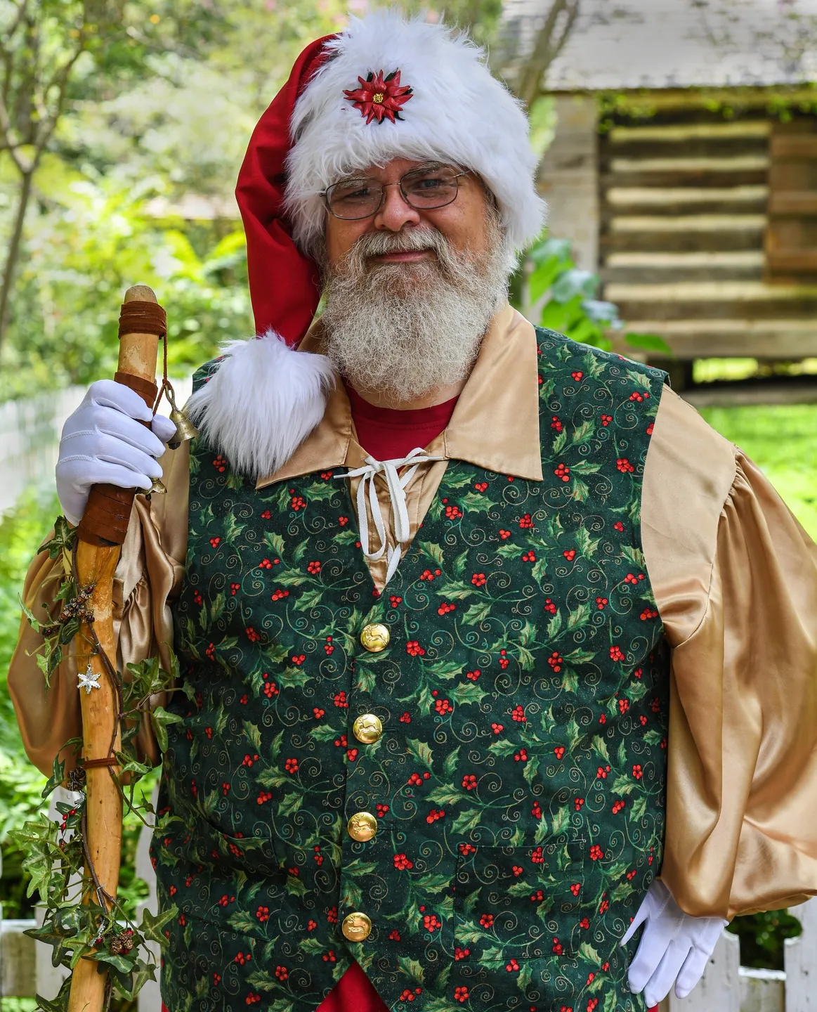 A man in santa claus outfit holding an umbrella.