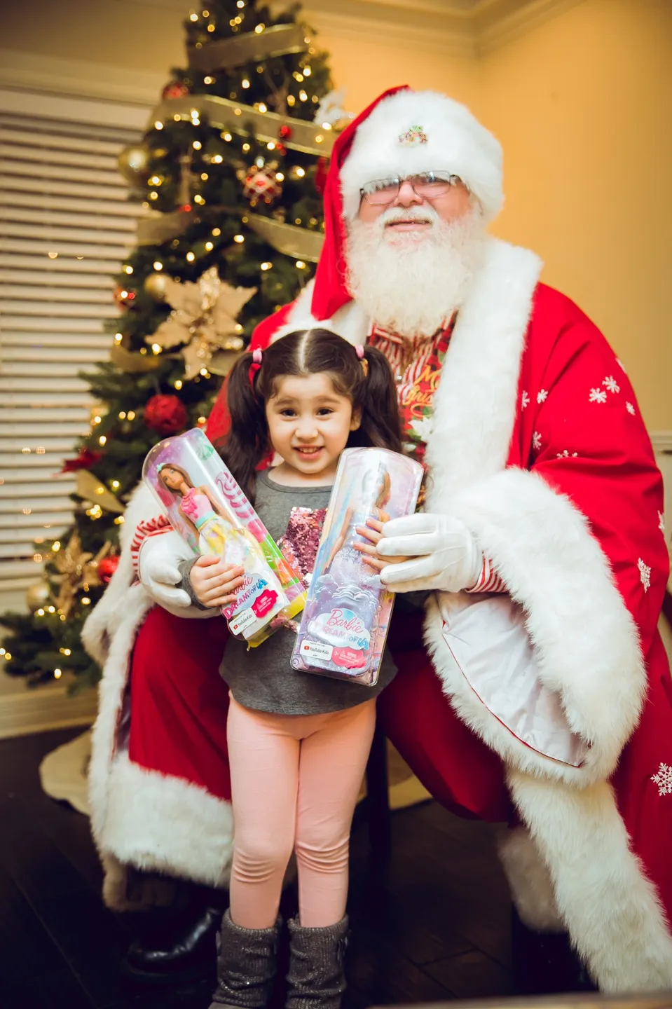 A little girl posing with santa claus