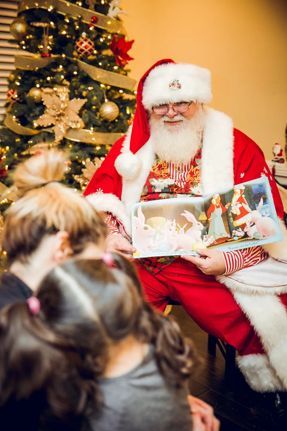 A man dressed as santa claus is holding a book.